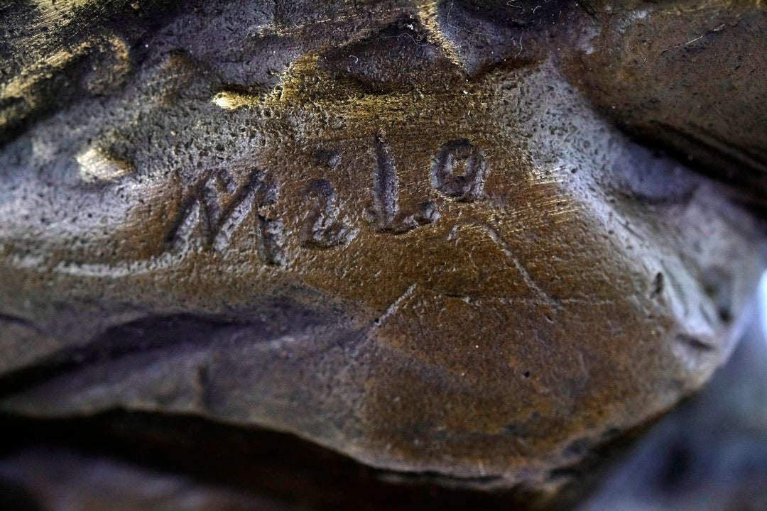 Bronze sculpture of an ibex on a rock
