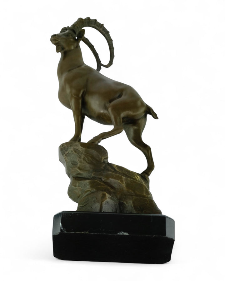 Bronze sculpture of an ibex on a rock