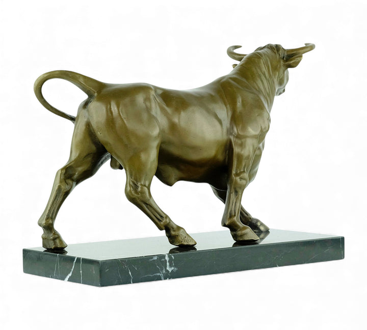Escultura de bronce de un toro feroz sobre una meseta de mármol