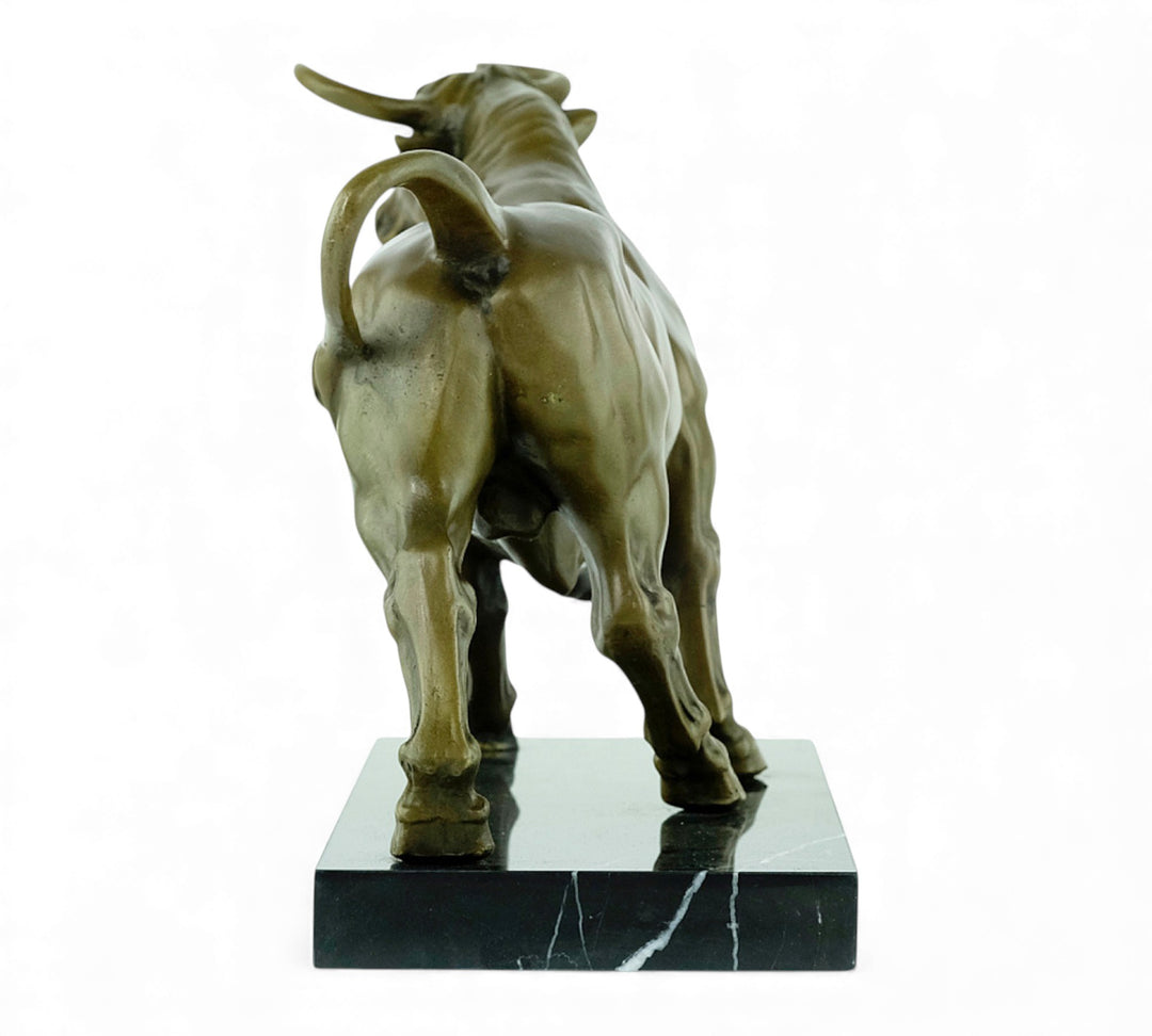 Escultura de bronce de un toro feroz sobre una meseta de mármol