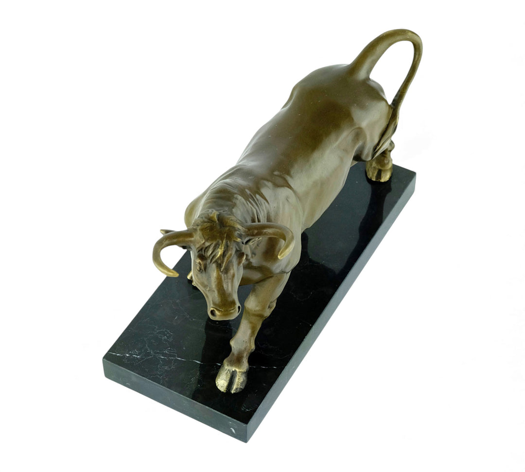 Escultura de bronce de un toro feroz sobre una meseta de mármol