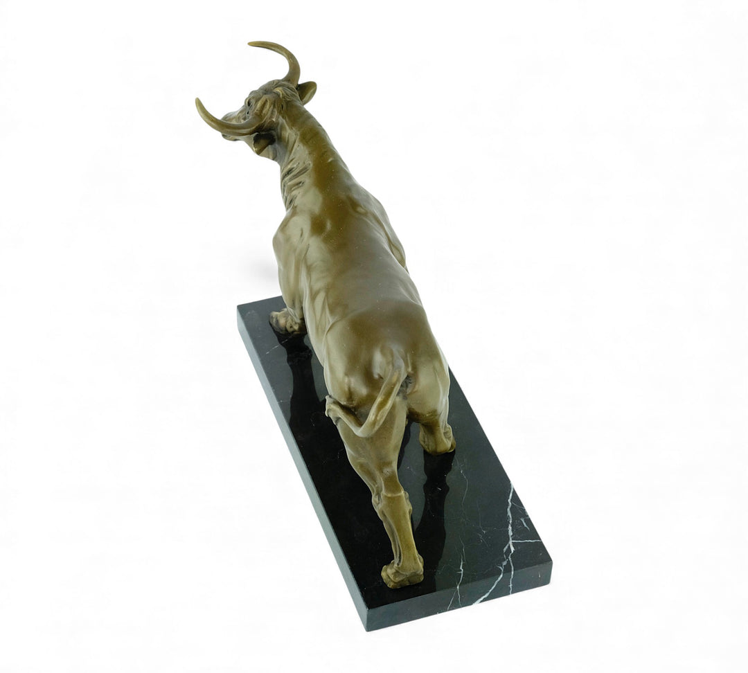 Escultura de bronce de un toro feroz sobre una meseta de mármol