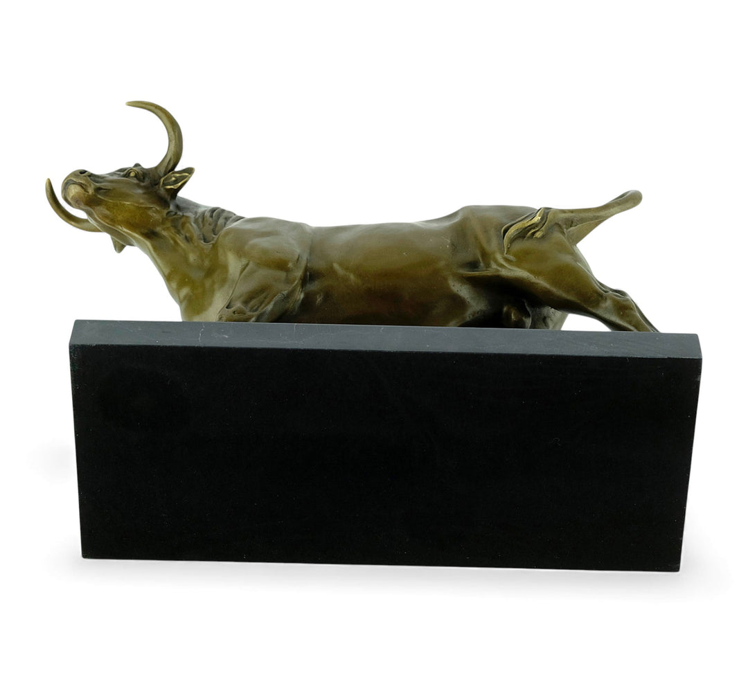 Escultura de bronce de un toro feroz sobre una meseta de mármol
