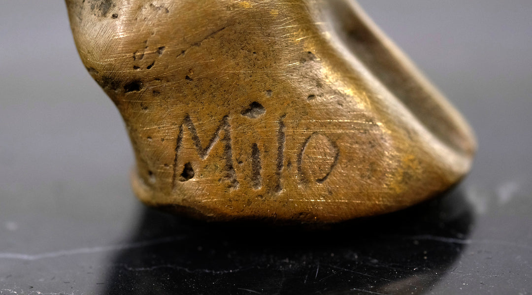 Escultura de bronce de un toro feroz sobre una meseta de mármol