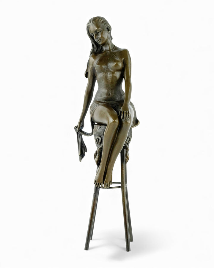 Bronze sculpture of a female on a barstool wearing a sensual dress