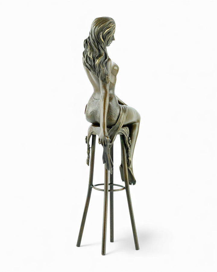 Bronze sculpture of a female on a barstool wearing a sensual dress