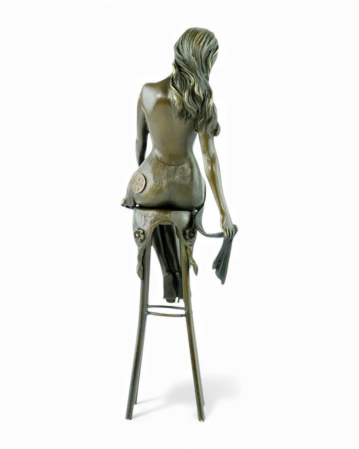 Bronze sculpture of a female on a barstool wearing a sensual dress
