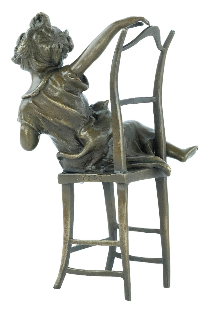 Bronze sculpture of a little girl on a chair playing with her cat