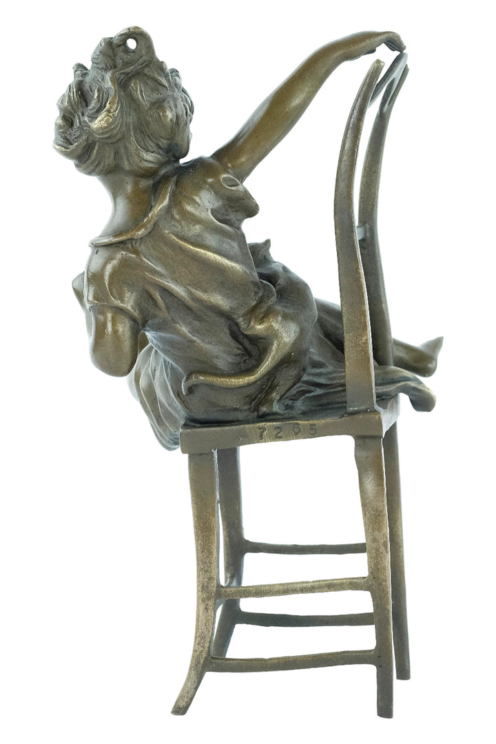 Bronze sculpture of a little girl on a chair playing with her cat
