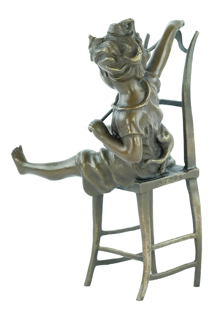 Bronze sculpture of a little girl on a chair playing with her cat