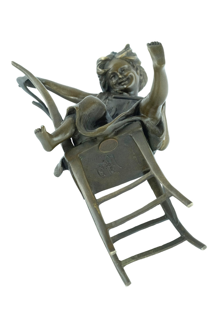 Bronze sculpture of a little girl on a chair playing with her cat