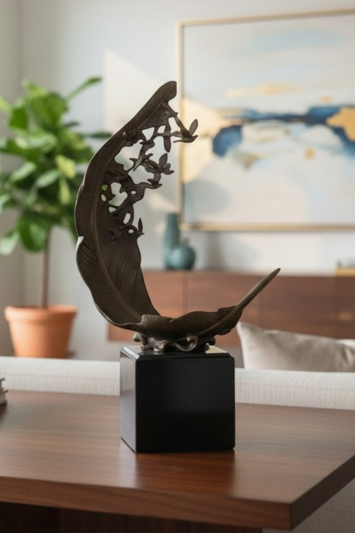 Escultura de bronce de palomas volando de una pluma
