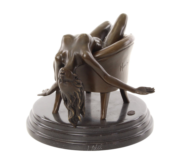 Bronze sculpture of a female nude laying on a chair