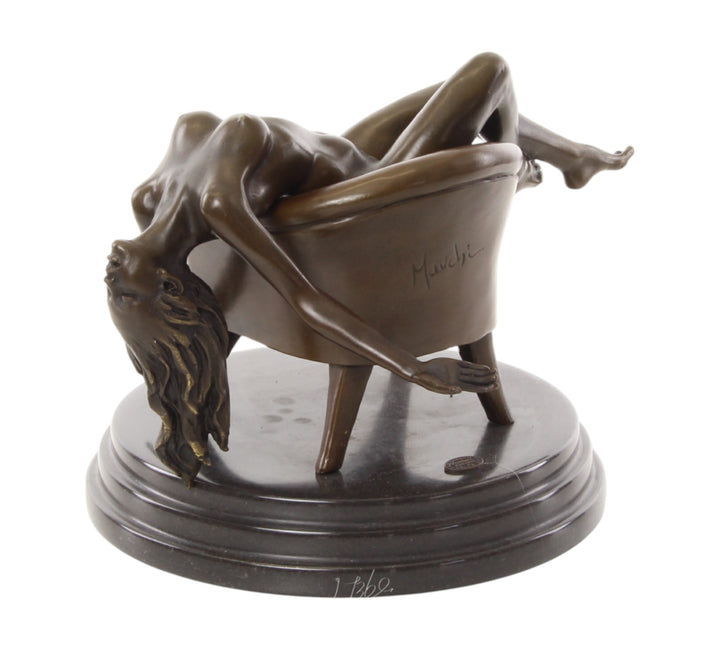 Bronze sculpture of a female nude laying on a chair