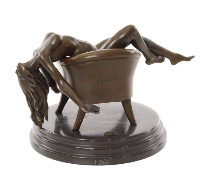 Bronze sculpture of a female nude laying on a chair