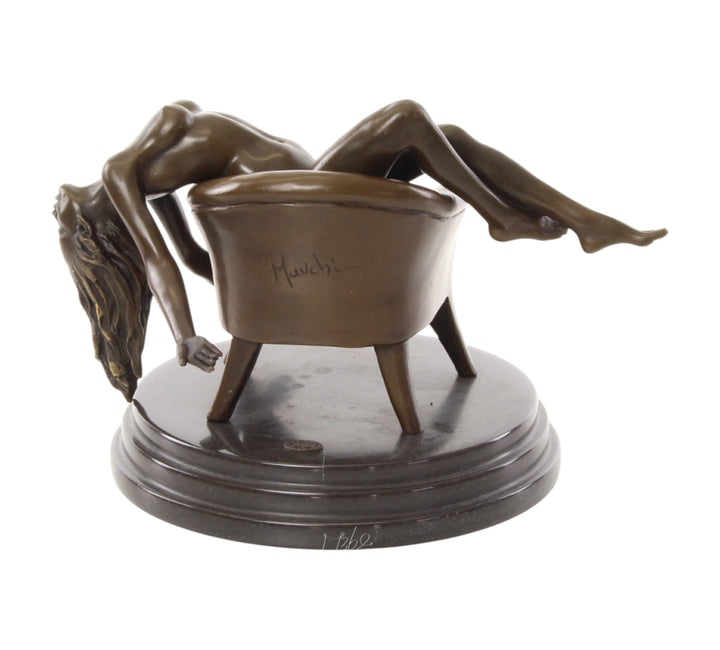 Bronze sculpture of a female nude laying on a chair
