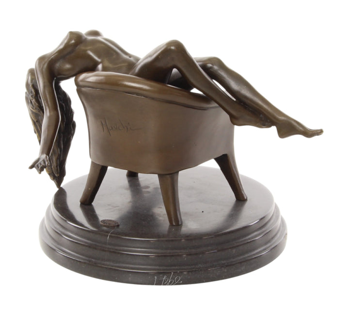 Bronze sculpture of a female nude laying on a chair