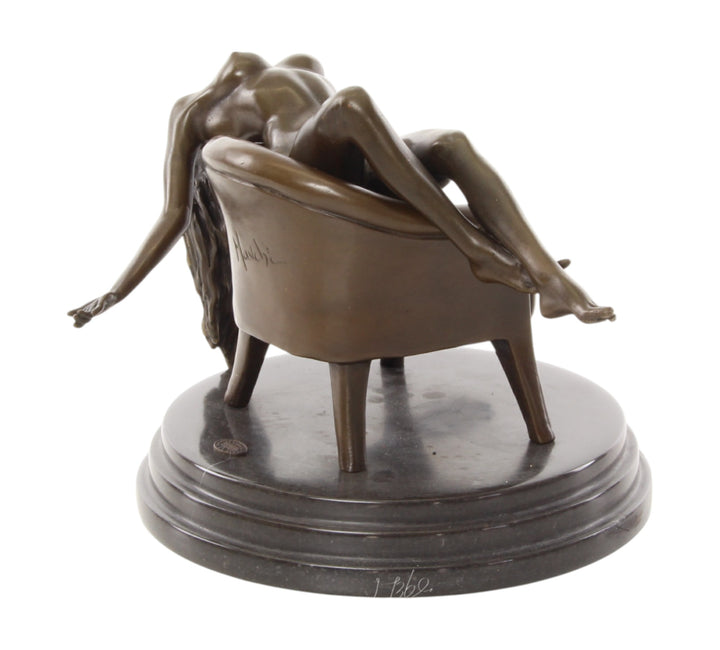 Bronze sculpture of a female nude laying on a chair