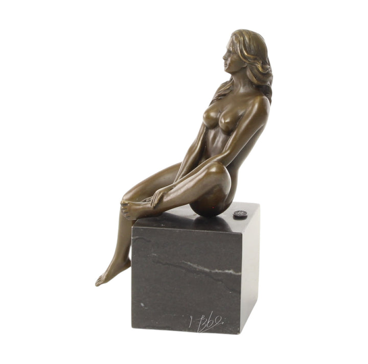 Bronze sculpture of a seated female nude with raised leg