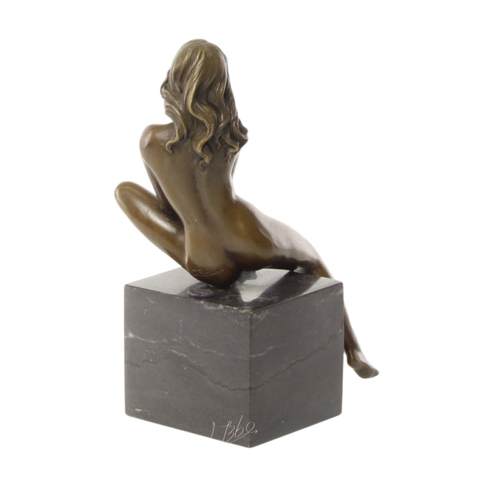 Bronze sculpture of a seated female nude with raised leg