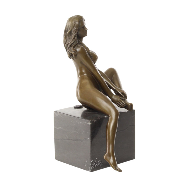 Bronze sculpture of a seated female nude with raised leg