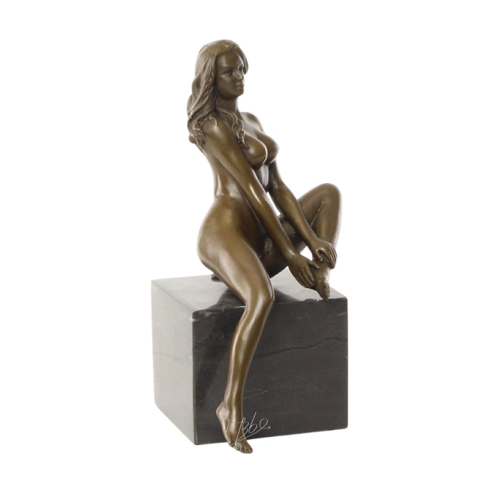 Bronze sculpture of a seated female nude with raised leg