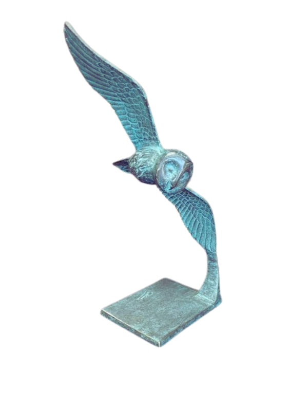 Bronze sculpture of an owl gliding through the air