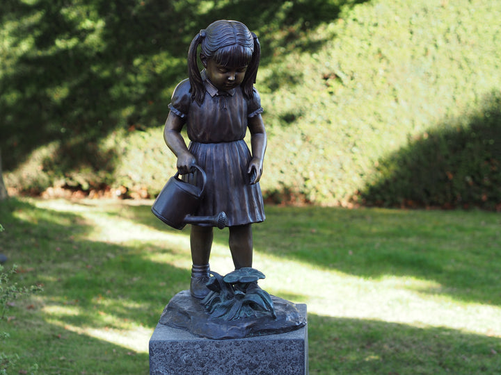 Bronze sculpture of a little girl watering the plants