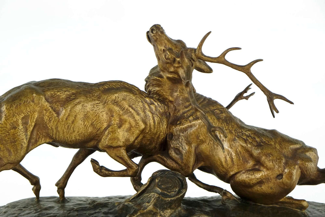 Antique bronze sculpture by Charles Masson depicting two stags in battle, showcasing intricate detail and 19th-century craftsmanship.