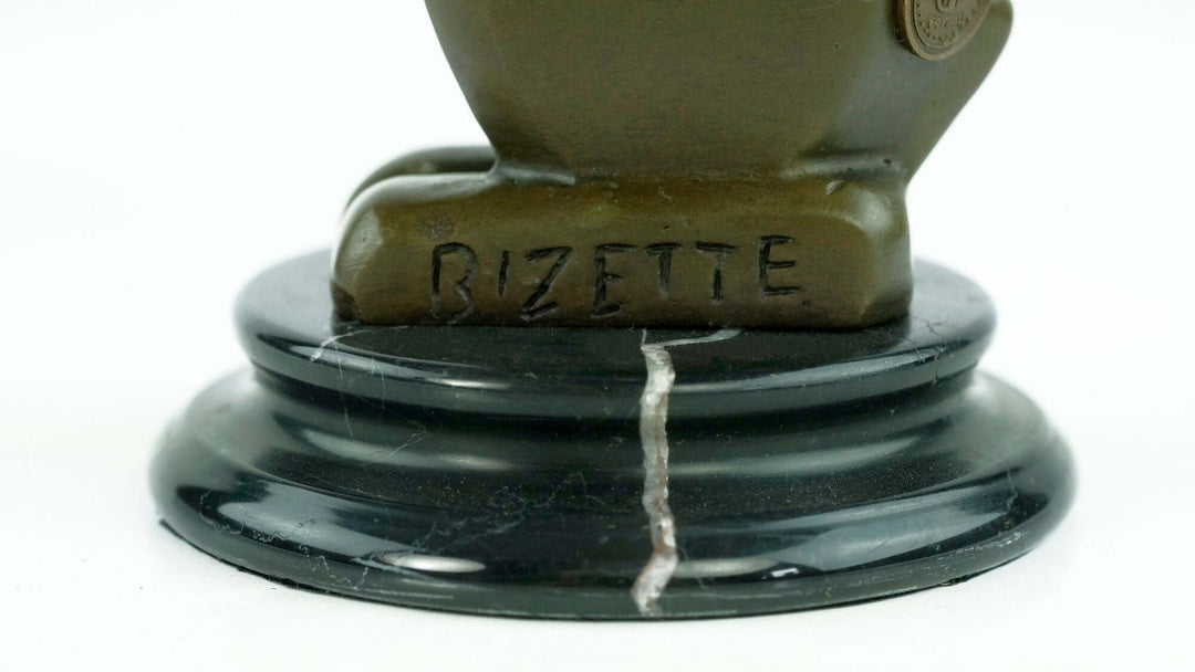 Close-up of Bizette signature on bronze rabbit sculpture base, showcasing Art Deco design and marble pedestal.