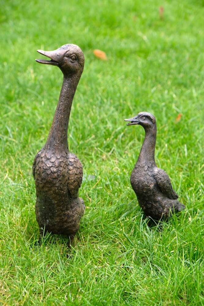 Bronze duck sculptures in garden, depicting a mother and duckling statue for outdoor decoration.