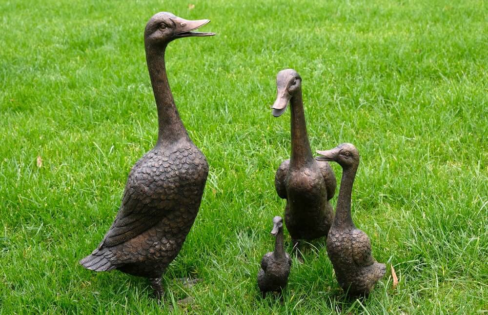 Set of 4 bronze duck family sculptures, including mother, father, and two ducklings, for outdoor decoration.
