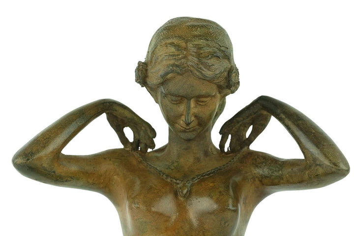 Bronze sculpture of a female nude adjusting a necklace, signed P. Chenet, showcasing exquisite detail and patina.
