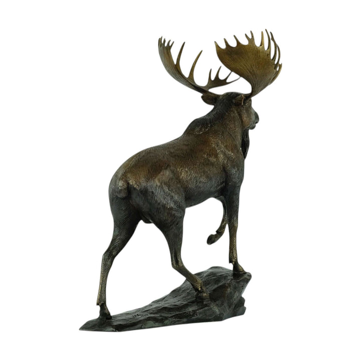 Lifelike bronze moose sculpture standing on a rock, showcasing intricate details and majestic stance.