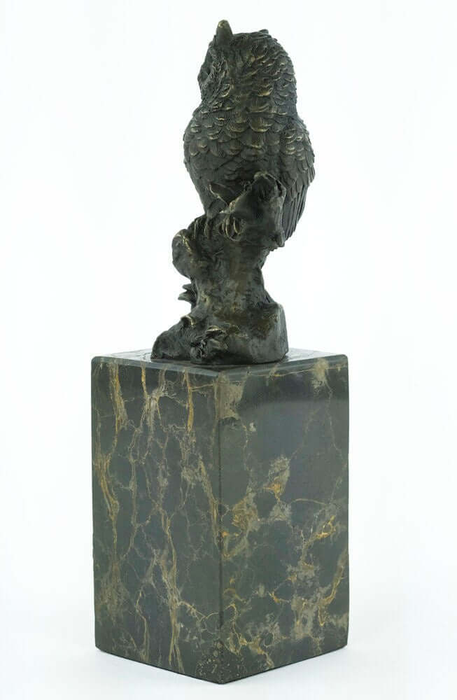 Bronze sculpture of an owl on a branch, mounted on a flamed marble base. Detailed craftsmanship, decorative art.