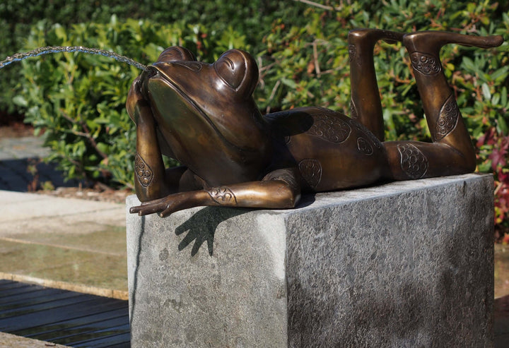 Bronze relaxing frog fountain sculpture with water spouting from mouth, designed for outdoor enjoyment.