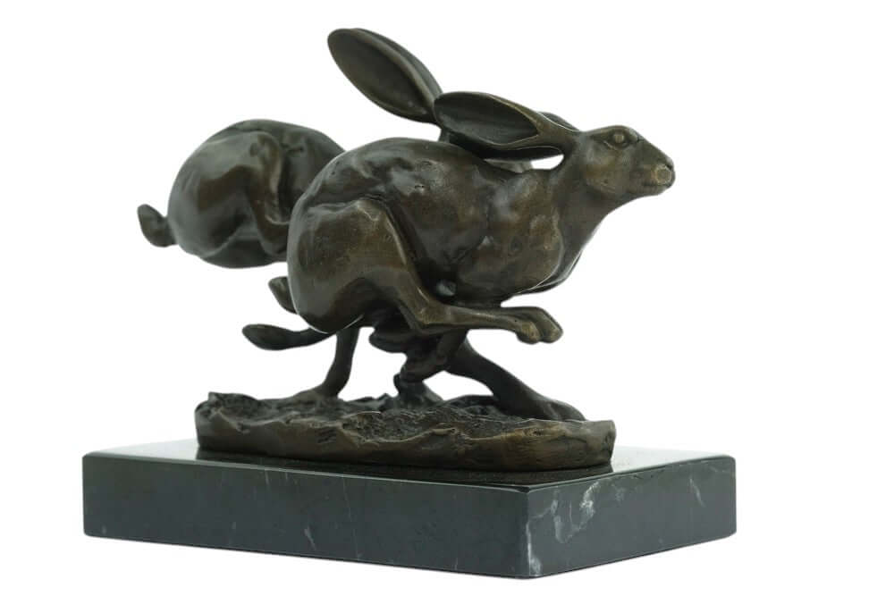 Bronze sculpture of two running hares on marble base, signed by Nick, showcasing dynamic action and artistry.