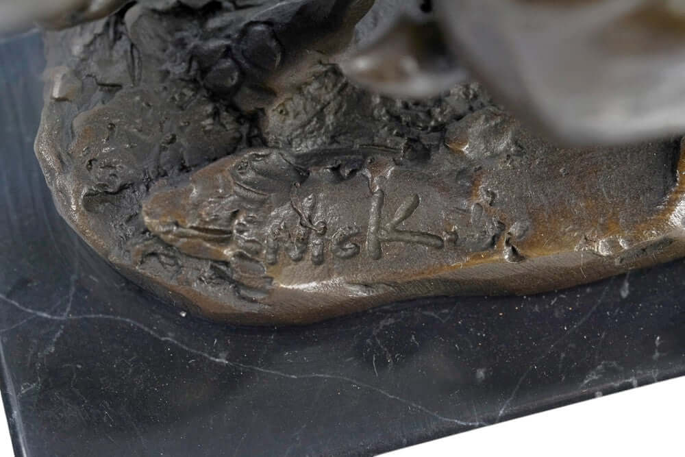 Close-up of the signature 'Nick' on the bronze running hares sculpture's base, highlighting craftsmanship.