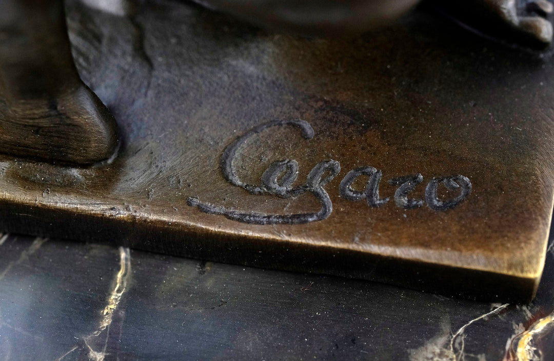 Close-up of 'Cesaro' signature on a bronze sculpture of Adonis, highlighting the craftsmanship and artistry.
