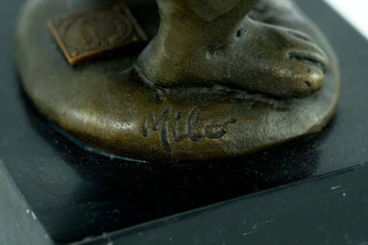 Close-up of a bronze bunny sculpture's signature 'Milo' on the base, showcasing craftsmanship quality.