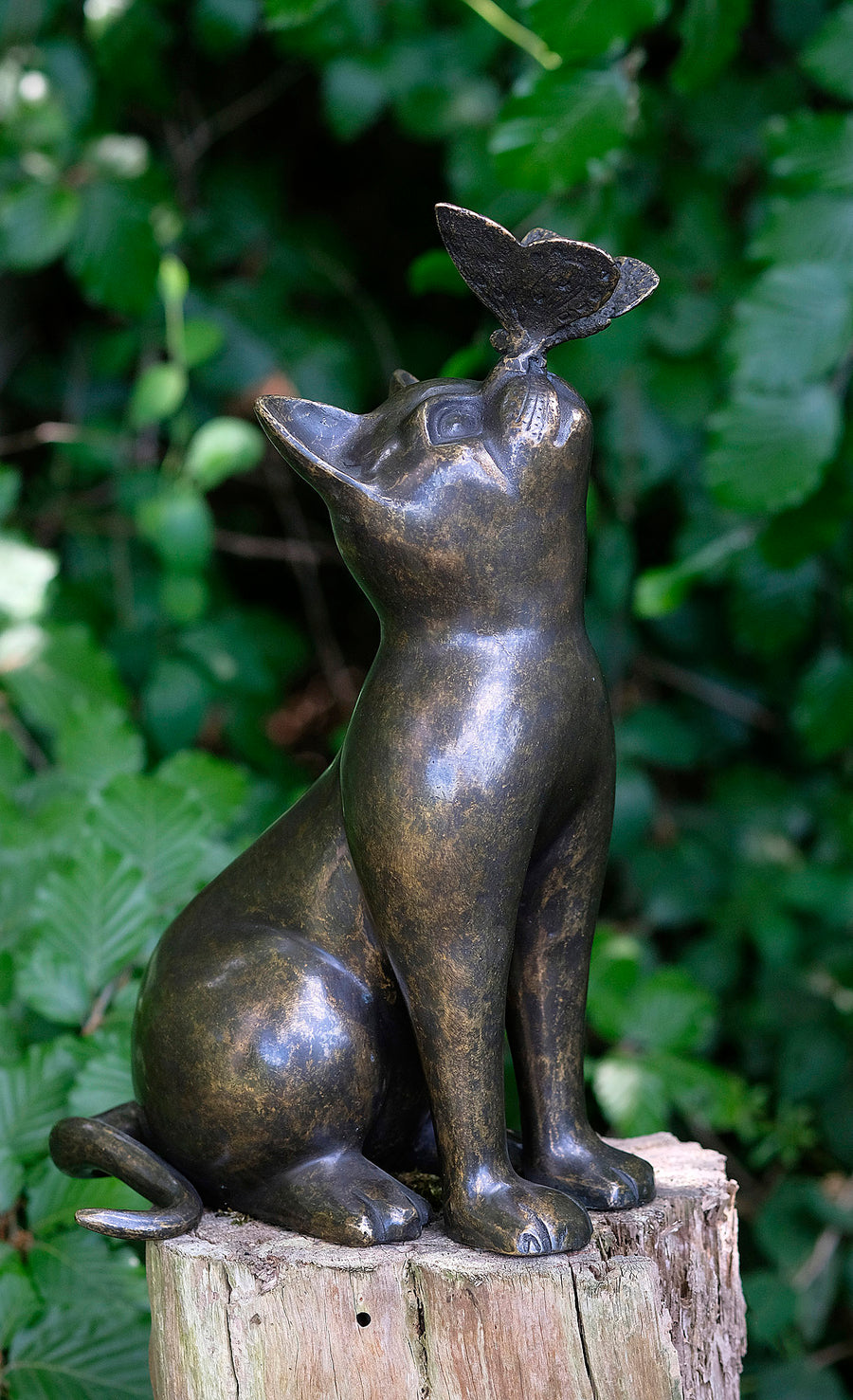 Bronze sculpture of a curious cat gazing at a butterfly, adding charm to home or garden decor.