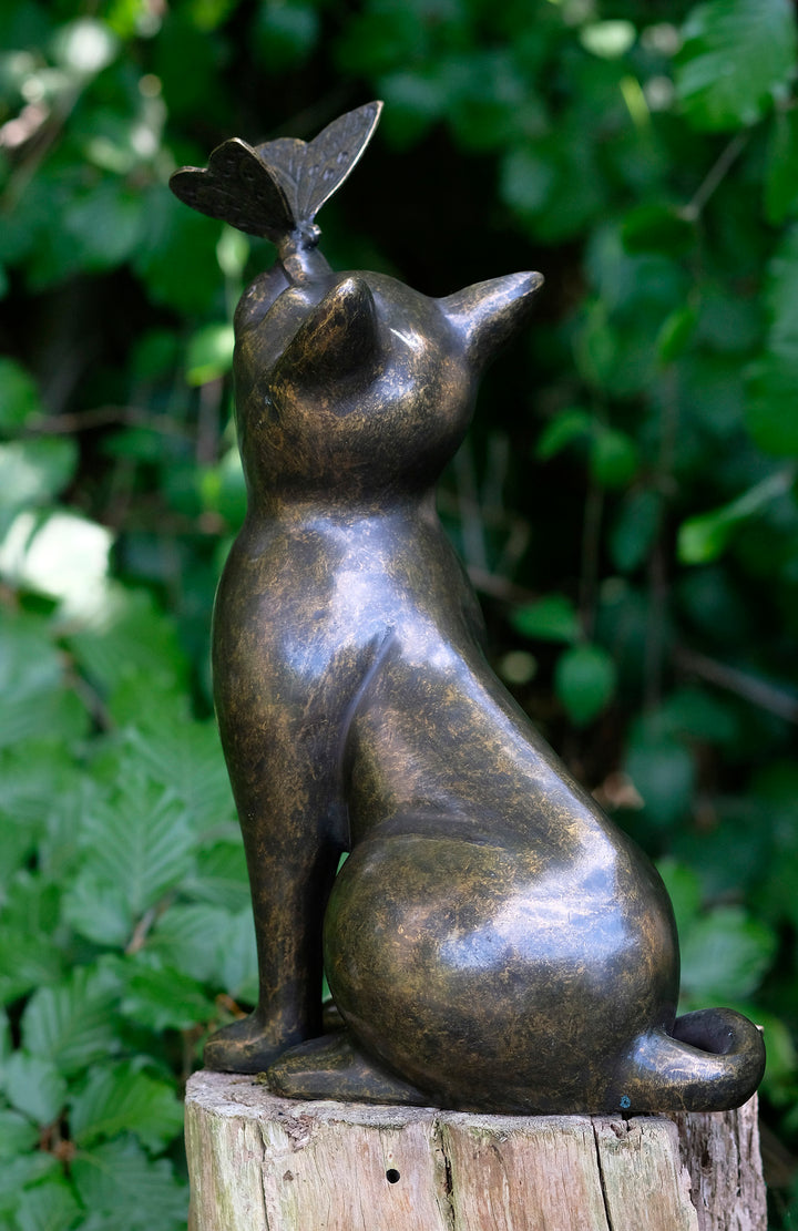 Bronze sculpture of a cat gazing at a butterfly, adding charm to home or garden decor, weather resistant, 38 x 25 cm.