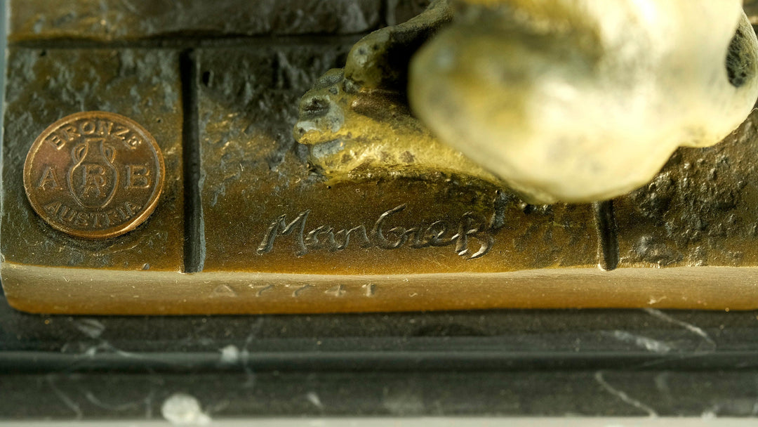 Close-up of the signature and bronze coin detail on a Cleopatra and panther bronze sculpture.