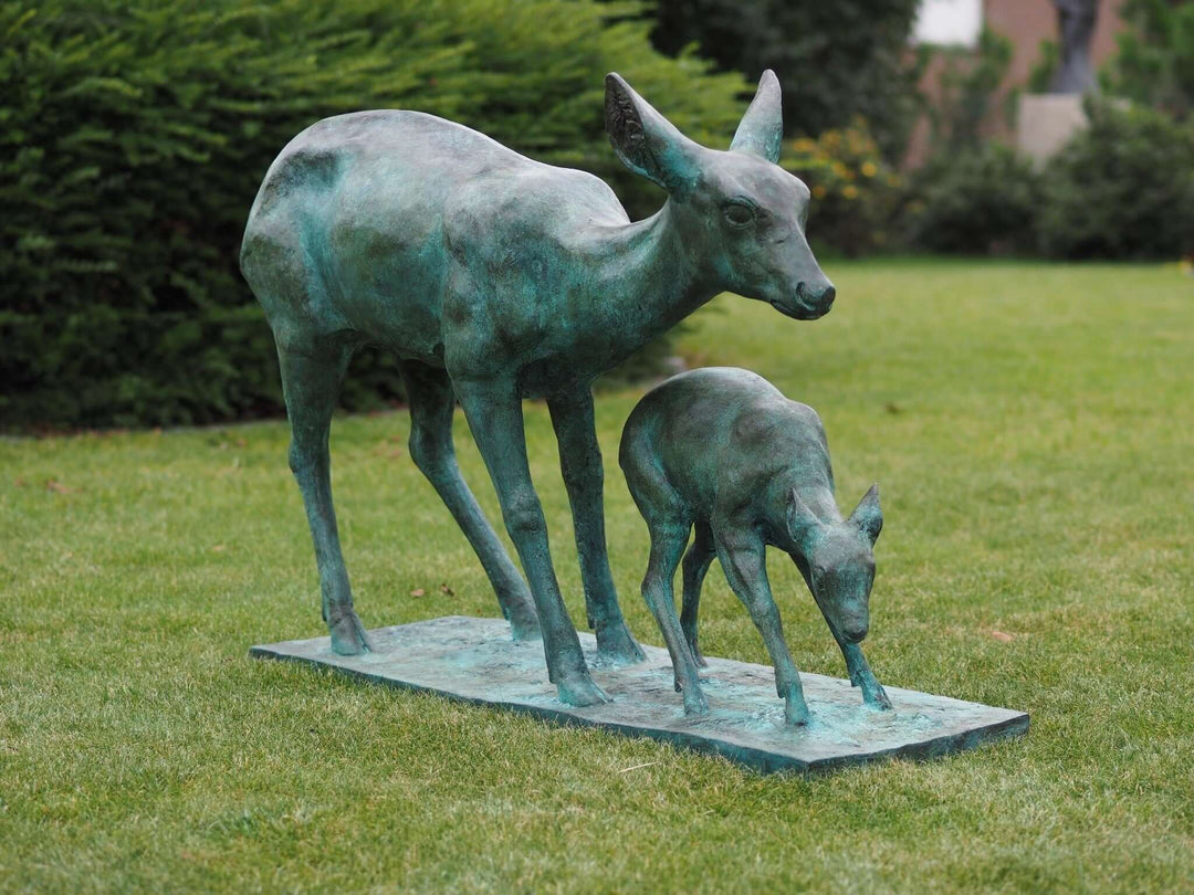 Bronze sculpture of a doe with her fawn, featuring green patina, perfect for garden decoration.