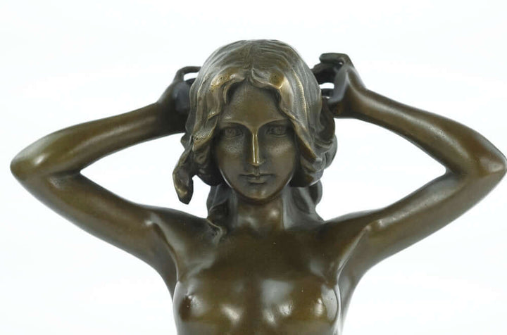 Bronze sculpture of a nude female playing with her hair, showcasing beauty and craftsmanship, inspired by Antonio Pittaluga.