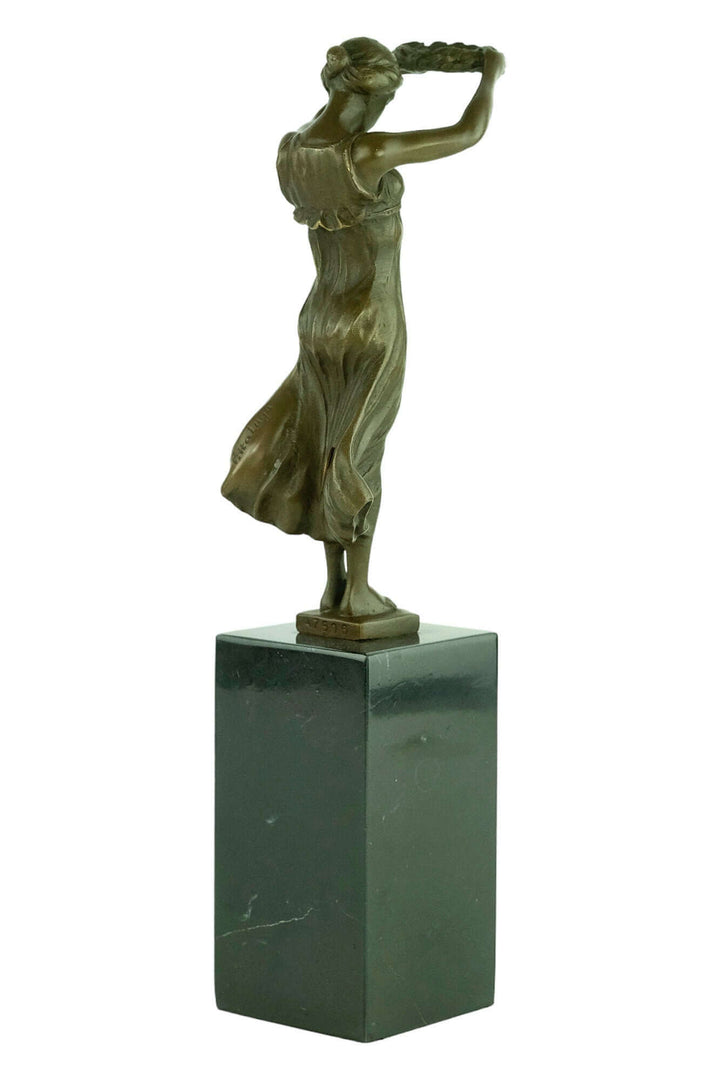 Bronze sculpture of Gelle Fra, the Golden Lady, standing with a wreath on a sleek pedestal. Iconic memorial art.