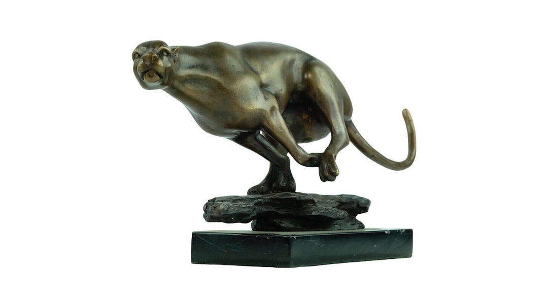 Bronze sculpture of a jaguar in motion, showcasing true-to-nature design and powerful appearance on a marble base.