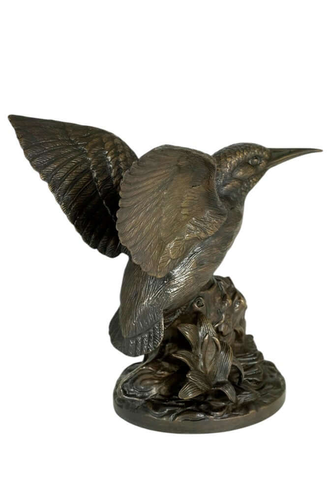 Detailed bronze sculpture of a kingfisher with wings spread, perched on a floral-decorated tree trunk.