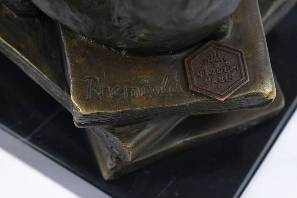 Close-up of the base of a bronze sculpture, featuring the signature of Hugo Rheinhold and a bronze plaque.