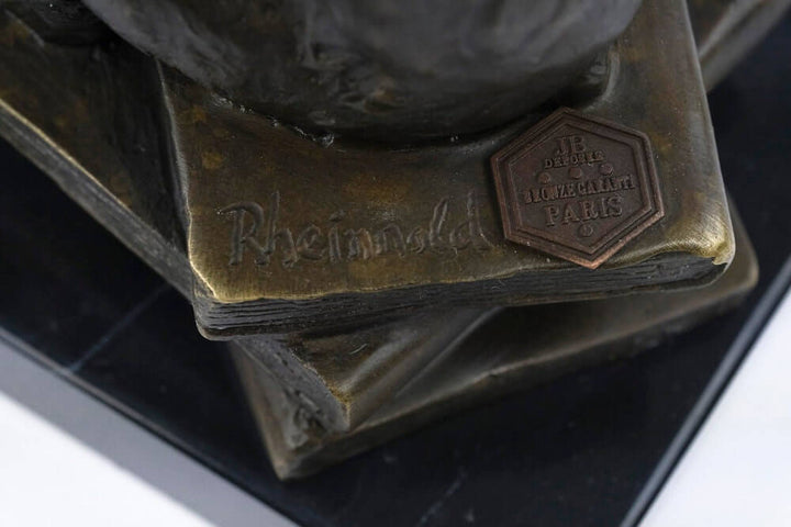 Close-up of the base of a bronze sculpture, featuring the signature of Hugo Rheinhold and a bronze plaque.